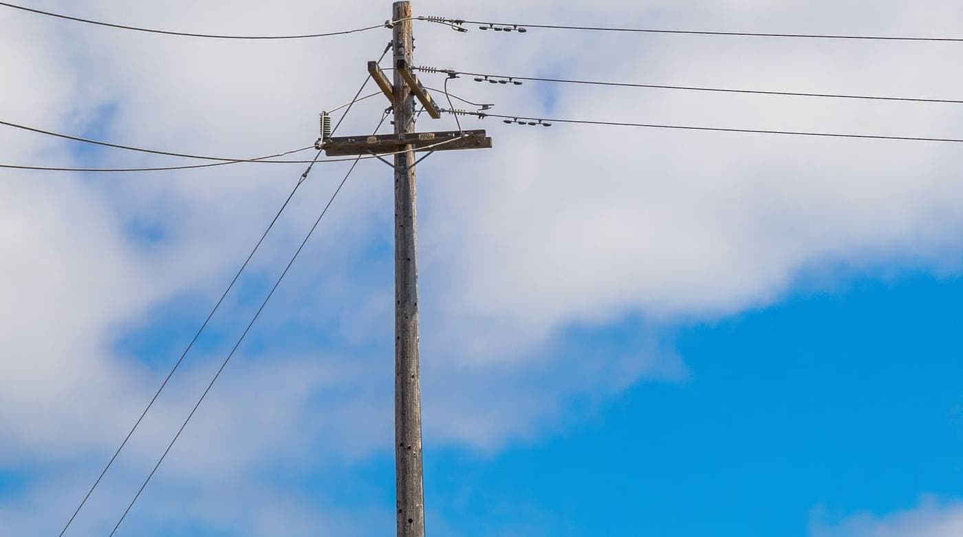 An electricity distribution pole and lines against open sky