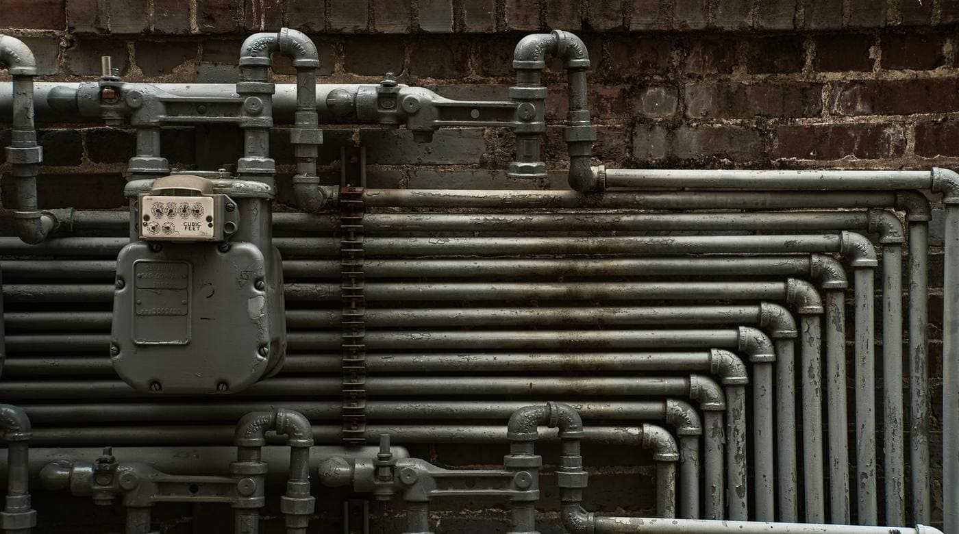 Water pipework running along a wall, with a meter